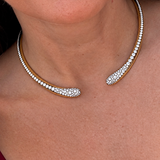 Model wearing a yellow gold open torque necklace set with pavé diamonds along both ends