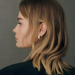 Side profile of a model wearing a yellow gold hoop earring with pavé diamonds