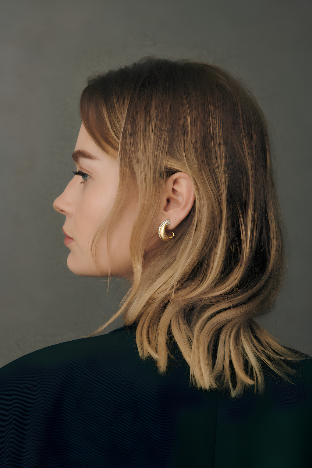 Side profile of a model wearing a yellow gold hoop earring with pavé diamonds