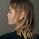 Side profile of a model wearing a yellow gold hoop earring with pavé diamonds