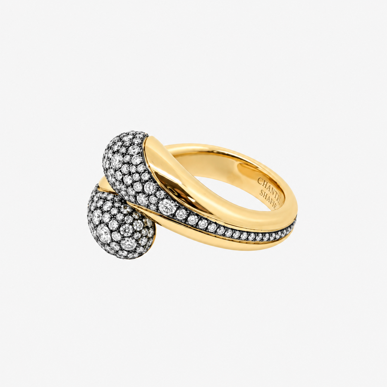 Angled view of the Chantel Shafie Ravello ring with rounded pave diamond ends set in blackened gold on a yellow gold band
